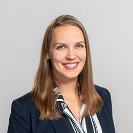 Headshot of Zuzana Zechovska, a young woman smiling on a simple grey background.
