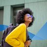 happy african female student with glasses and bag going to university