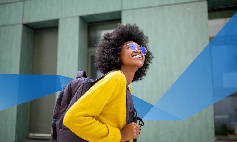 happy african female student with glasses and bag going to university