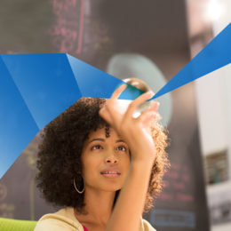 Young African American woman holding something shiny in her hand and looking at it.