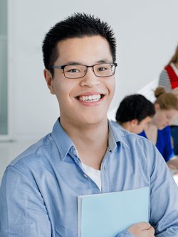 bao huy holding a book and smiling