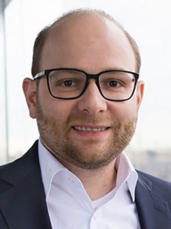 bastian nominacher wearing a blue blazer and smiling