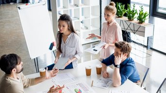 one asian and one european business woman talk to male colleagues.