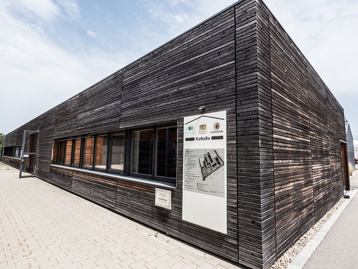 A black wooden building with the guidance map on the wall