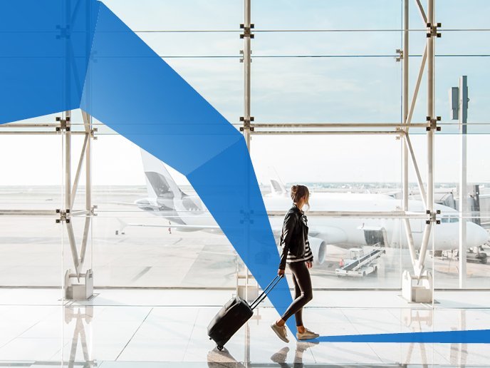 View on the aiport window with woman walking with suitcase at the departure hall of the airport. Wide angle view with copy space