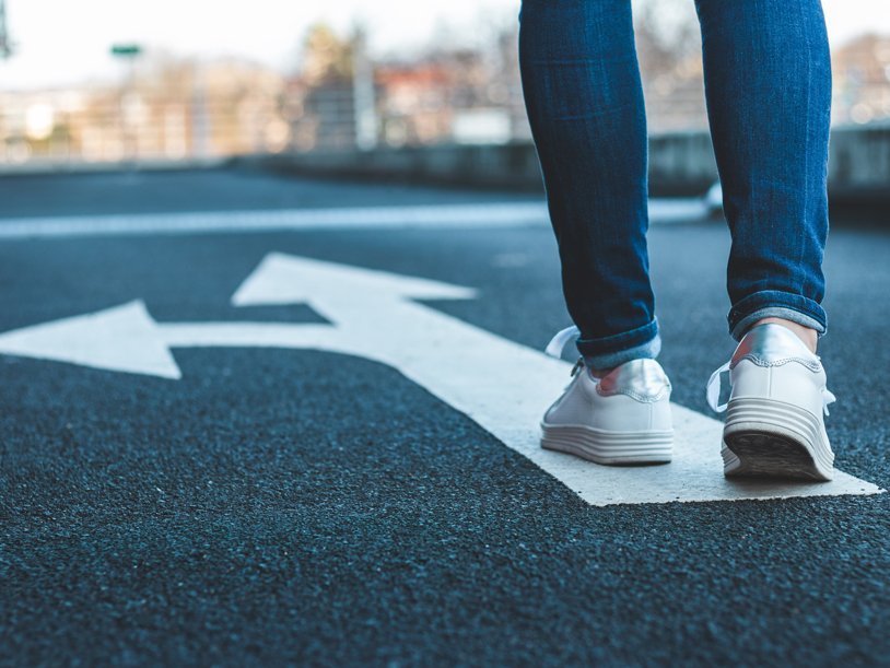 Walking on directional sign on asphalt road