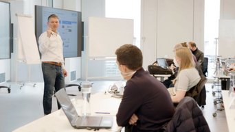 Prof. Thomas Hutzschenreuter a lecture in a classroom together with students