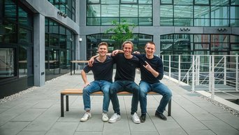 Philipp (in the middle) with his two co-founders Vladislav Samoilov and Tim Meinhardt sitting on a bench