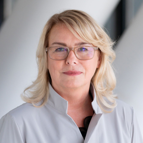 Headshot of Edeltraud Hanappi-Egger, a midle-aged woman on a light gray background. 
