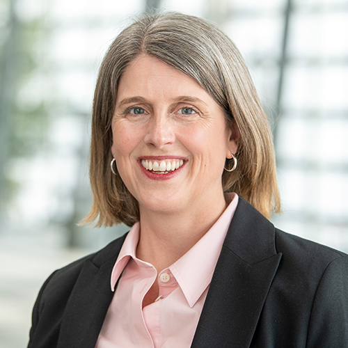 Headshot of Barbara Tasch, a middle aged woman smiling and standing inside the TUM campus in Munich.