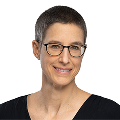 Portrait of Anke Dauetel. She has short grey hair, wears glasses and smiles at the camera.