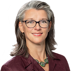 Headshot of Ute Helfers, a middle age woman smiling on a simple white  background.