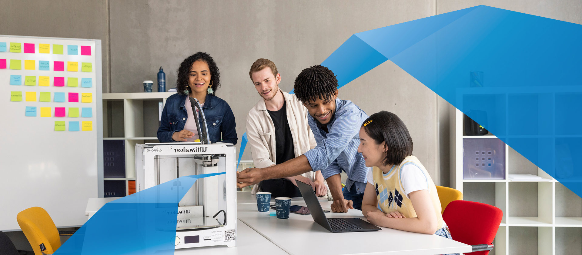 Diverse group of students working together by 3D printer. 