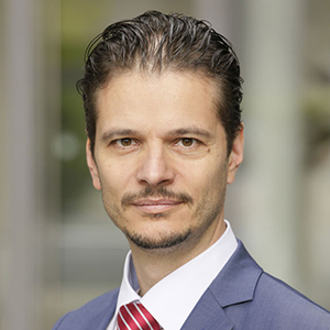 Headshot of Wolfgang Rams, a man with short dark hair, looking at the camera.